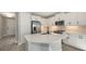 Bright kitchen featuring white cabinets, stainless steel appliances, and a spacious island with a quartz countertop at 2321 Blue Mahoe Ln, Sarasota, FL 34240