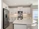 Modern kitchen with white cabinets, stainless steel appliances, and a central island with a sink at 2321 Blue Mahoe Ln, Sarasota, FL 34240