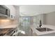Open kitchen showcasing stainless steel appliances, quartz countertops, and a view of the dining area at 2321 Blue Mahoe Ln, Sarasota, FL 34240