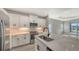 Contemporary kitchen with white cabinets, stainless steel appliances, and a view into the living space at 2321 Blue Mahoe Ln, Sarasota, FL 34240