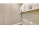 Bright laundry room featuring ample overhead cabinet storage and utility connections for convenience at 2321 Blue Mahoe Ln, Sarasota, FL 34240