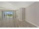 Bright living room featuring neutral walls, wood-look tile flooring, and access to a screened lanai at 2321 Blue Mahoe Ln, Sarasota, FL 34240