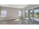 Modern living room with tile flooring, sliding glass doors to the patio, and neutral wall color for customization at 2321 Blue Mahoe Ln, Sarasota, FL 34240