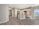 Open-concept kitchen and living area featuring light-colored walls and seamless wood-look flooring throughout at 2321 Blue Mahoe Ln, Sarasota, FL 34240