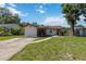 Quaint single-story home featuring a red door and a classic concrete driveway at 2558 Hawthorne St, Sarasota, FL 34239