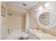 Bathroom features neutral tile, and a round mirror over the sink at 2639 Woodgate Ln # H8, Sarasota, FL 34231