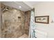 A shower tiled in brown tones includes a shower head and a built-in shelf at 2639 Woodgate Ln # H8, Sarasota, FL 34231