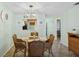 Bright dining area with view to kitchen, featuring a glass table, wicker chairs, and a modern chandelier at 2639 Woodgate Ln # H8, Sarasota, FL 34231