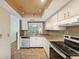 This cozy kitchen features white cabinets, tile backsplash, and modern appliances at 2639 Woodgate Ln # H8, Sarasota, FL 34231