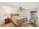 This bright bedroom features a stylish bed frame, a ceiling fan, and tile floors at 2639 Woodgate Ln # H8, Sarasota, FL 34231
