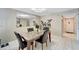 View of dining room with neutral walls, large mirror, flower decor, and tile flooring at 2763 Woodgate Ln # 211, Sarasota, FL 34231
