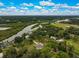 Stunning aerial view of riverfront property surrounded by lush greenery and blue skies with fluffy white clouds at 2912 51St E St, Bradenton, FL 34208