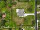 Bird's eye view of a home with a long driveway, lush green lawn and mature trees on a sunny day at 2912 51St E St, Bradenton, FL 34208