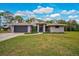 Charming one-story home boasts a well-manicured lawn, gray exterior, and an attached two-car garage at 2912 51St E St, Bradenton, FL 34208