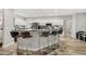 This is a kitchen with white cabinets, black hardware, stainless steel appliances and bar stool seating at 2912 51St E St, Bradenton, FL 34208