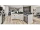 Updated kitchen showcases stainless steel appliances, stone countertops, white cabinets and wood-look tile flooring at 2912 51St E St, Bradenton, FL 34208