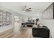 Spacious living room with wood-look tile floors, a black leather sectional sofa, and an oversized ceiling fan at 2912 51St E St, Bradenton, FL 34208