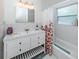 Bright bathroom with vanity and bathtub featuring floral shower curtain at 2933 Michigan St, Sarasota, FL 34237