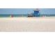 Picturesque beach scene with white sand, lifeguard tower, and people enjoying the sunny day at 2933 Michigan St, Sarasota, FL 34237