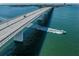 Aerial view of bridge over sparkling water with a speedboat, showcasing transportation and recreation at 2933 Michigan St, Sarasota, FL 34237
