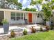 Close-up of the front porch with an orange door, potted plants, and a small seating area at 2933 Michigan St, Sarasota, FL 34237