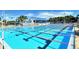 Community pool with marked lanes, bleachers, and a pool house on a bright, sunny day at 3276 Westford Ln, #117,, Sarasota, FL 34231