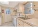 Efficient kitchen features white appliances, ample counter space, and a window providing natural light at 3276 Westford Ln, #117,, Sarasota, FL 34231