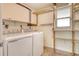 Functional laundry area with appliances, shelving, and a window for natural light at 3276 Westford Ln, #117,, Sarasota, FL 34231