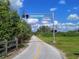 The Legacy Trail, lined with lush greenery, is perfect for outdoor activities, with a clear blue sky overhead at 3276 Westford Ln, #117,, Sarasota, FL 34231