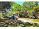 Community playground featuring a slide and various climbing structures surrounded by lush, mature trees at 3276 Westford Ln, #117,, Sarasota, FL 34231