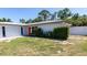 Charming single-story home with a bright orange front door and mature landscaping at 3338 Roslyn Rd, Venice, FL 34293
