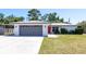 Charming single-story home featuring an attached garage, carport, and an inviting bright orange front door at 3338 Roslyn Rd, Venice, FL 34293