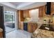 Well-lit kitchen with light wood cabinetry, modern appliances, and sliding doors to the screened patio and pool at 3338 Roslyn Rd, Venice, FL 34293