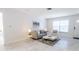Bright living room features tile floors, contemporary furnishings, and plenty of natural light from the front door and window at 3338 Roslyn Rd, Venice, FL 34293