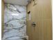 Beautiful shower featuring contemporary marble accents, a built-in shelf, and modern shower fixtures at 3338 Roslyn Rd, Venice, FL 34293