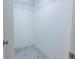 Bright walk-in closet is ready for customization with an overhead rack for hanging and tiled floor at 3338 Roslyn Rd, Venice, FL 34293