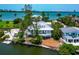 Aerial view of beautiful waterfront home surrounded by tropical landscaping, near the beach at 3737 Bayou Louise Ln, Sarasota, FL 34242