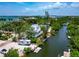 Aerial view showing waterfront home with boat dock and lush landscaping at 3737 Bayou Louise Ln, Sarasota, FL 34242