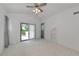 Spacious bedroom with a ceiling fan, neutral carpet, and a sliding glass door to the balcony at 3737 Bayou Louise Ln, Sarasota, FL 34242