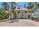 Beautiful two-story home featuring a metal roof, white accents, and tropical landscaping at 3737 Bayou Louise Ln, Sarasota, FL 34242