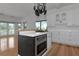 Well-appointed kitchen with white cabinetry, tiled countertops, gas cooktop, and view to an adjacent living space at 3737 Bayou Louise Ln, Sarasota, FL 34242