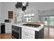 Charming kitchen with white cabinets, stainless appliances, and views into the living area at 3737 Bayou Louise Ln, Sarasota, FL 34242