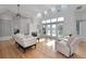 Bright living room with wood floors, white furniture, fireplace, skylights, and French doors to a balcony at 3737 Bayou Louise Ln, Sarasota, FL 34242