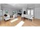 Open-concept living room with wood floors, white furniture, and access to the kitchen and balcony at 3737 Bayou Louise Ln, Sarasota, FL 34242