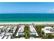 A high-angle view of condo buildings near a white sandy beach and turquoise ocean at 3802 Gulf Of Mexico Dr # A205, Longboat Key, FL 34228