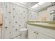 Well-lit bathroom with a palm tree shower curtain and white fixtures at 3802 Gulf Of Mexico Dr # A205, Longboat Key, FL 34228
