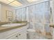 Well-lit bathroom featuring a sink, toilet, and patterned shower curtain at 3802 Gulf Of Mexico Dr # A205, Longboat Key, FL 34228