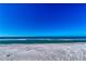 Wide shot of a sandy beach featuring the ocean and a clear, bright blue sky at 3802 Gulf Of Mexico Dr # A205, Longboat Key, FL 34228