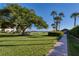 Lush landscaped property, a sidewalk path leading to the beach, palm trees, and a gazebo at 3802 Gulf Of Mexico Dr # A205, Longboat Key, FL 34228