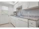 Bright, clean kitchen featuring white cabinets, modern appliances, and a granite countertop at 3802 Gulf Of Mexico Dr # A205, Longboat Key, FL 34228